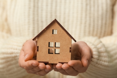 Woman,In,Warm,Sweater,Holding,Decorative,House,,Closeup