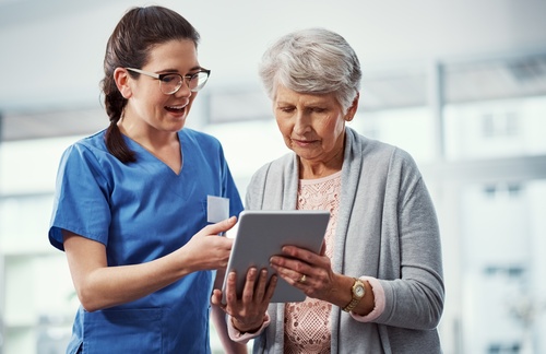 Talking,,Tablet,And,Nurse,With,Elderly,Woman,In,Clinic,For